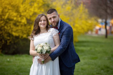 Foto de Joven pareja recién casada, teniendo fotos tomadas en su boda al aire libre, primavera - Imagen libre de derechos