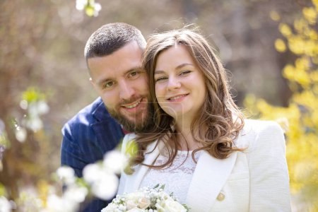 Téléchargez les photos : Jeune couple nouvellement marié, ayant des photos prises sur leur mariage à l'extérieur, printemps - en image libre de droit