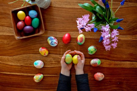 Téléchargez les photos : Petit blond tout-petit garçon enfant colorier des œufs de Pâques à la maison, la tradition de la République tchèque avec des brindilles et des œufs - en image libre de droit