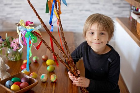 Photo for Little blond toddler boy child coloring easter eggs at home, Czech Republic tradition with twigs and eggs - Royalty Free Image