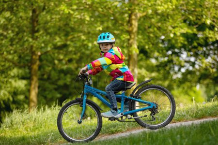 Téléchargez les photos : Garçon heureux, s'amuser dans le parc avec un vélo sur une belle journée. Enfant actif - en image libre de droit