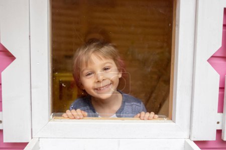 Téléchargez les photos : Enfants, garçon et fille, jouant dans la maison en bois rose pour les enfants dans la cour arrière - en image libre de droit