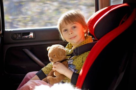 Photo for Cute children, boy and girl siblings, sitting in car seats in car, traveling. Family going to family vacation - Royalty Free Image