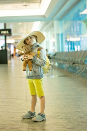 Foto de Niños, hermanos, viajando para vacaciones de verano, esperando en el aeropuerto para abordar el avión - Imagen libre de derechos