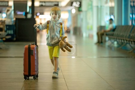 Téléchargez les photos : Enfants, garçons frères, voyageant pour des vacances d'été, attendant à l'aéroport pour monter à bord de l'avion - en image libre de droit
