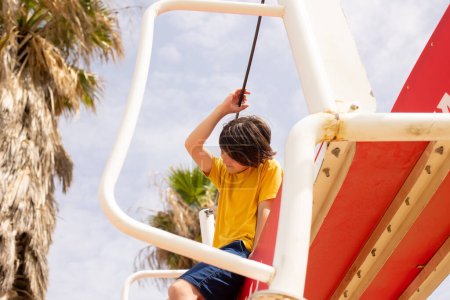 Téléchargez les photos : Enfants heureux, garçons, jouant sur l'aire de jeux à Tel Aviv, Israël par une chaude journée d'été - en image libre de droit