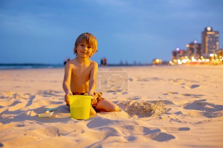 Photo for Child, boy, playing on the beach in Tel Aviv in the evening, summertime - Royalty Free Image