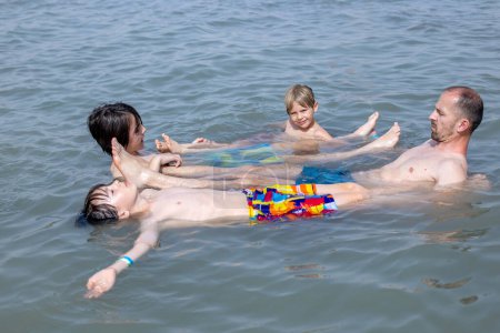 Téléchargez les photos : Enfant, garçon, flottant dans la mer Morte par une journée d'été très chaude - en image libre de droit