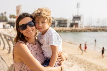Foto de Madre e hijo, familia disfrutando de las vistas al mar en Tel Aviv en un caluroso día de verano, tarde - Imagen libre de derechos
