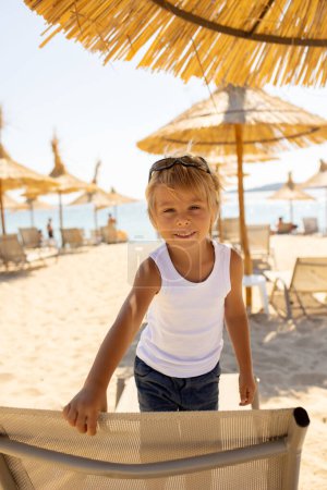 Foto de Child, cute boy, playing on the beach in the sand, enjoying summer, number sign - Imagen libre de derechos