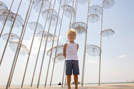Foto de Child, visiting famous art monument of umbrellas in Thessaloniki on a summer day, Greece - Imagen libre de derechos