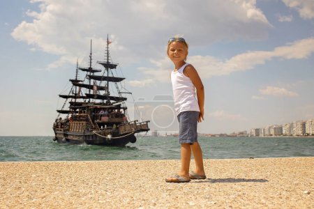 Photo for Child, visiting Thessaloniki during the summer with his pet dog and family, Greece - Royalty Free Image