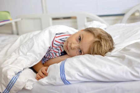 Téléchargez les photos : Petit enfant d'âge préscolaire, couché à l'hôpital après un accident, mère l'accompagnant - en image libre de droit