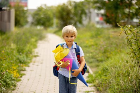 Foto de Cute blond child, boy with candy cone on first school day in Czech Republic, old German tradition that what transfer to Czzech as well - Imagen libre de derechos