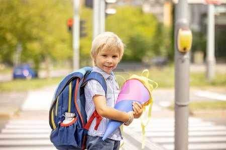 Téléchargez les photos : Cute blond child, boy with candy cone on first school day in Czech Republic, old German tradition that what transfer to Czzech as well - en image libre de droit
