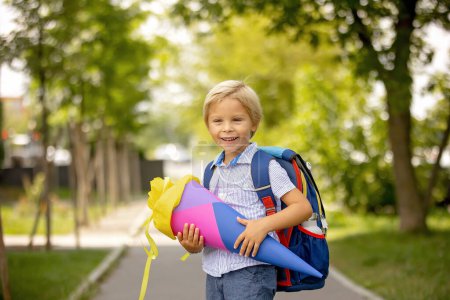 Téléchargez les photos : Cute blond child, boy with candy cone on first school day in Czech Republic, old German tradition that what transfer to Czzech as well - en image libre de droit