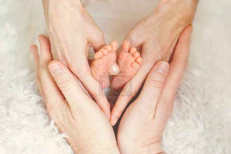 Foto de Pies de bebé en las manos de los padres, haciendo forma de corazón, amor, emociones positivas - Imagen libre de derechos