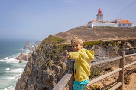 Foto de Familia con niños, hermanos, visitando el punto más occidental de Europa, Cabo Da Roca, durante las vacaciones familiares de verano en Portugal - Imagen libre de derechos