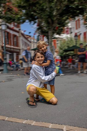 Téléchargez les photos : Famille, visite d'une petite ville en France, Saint Jean de Luz, pendant les vacances d'été, voyage avec les enfants en Europe - en image libre de droit