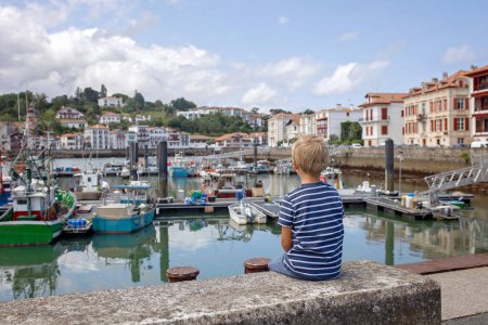 Téléchargez les photos : Famille, visite d'une petite ville en France, Saint Jean de Luz, pendant les vacances d'été, voyage avec les enfants en Europe - en image libre de droit