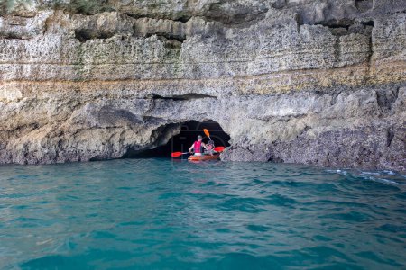 Téléchargez les photos : Enfants, profitant de Benagil, Portugal. Grotte de Benagil à l'intérieur d'Algar de Benagil, célèbre grotte marine de la côte de l'Algarve, Lagoa. Bonne famille en canot - en image libre de droit