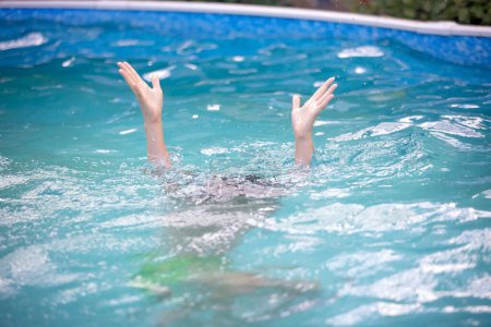 Téléchargez les photos : Les personnes donnent l'eau, demandent de l'aide, la personne se noie dans la piscine, mains seulement visibles - en image libre de droit