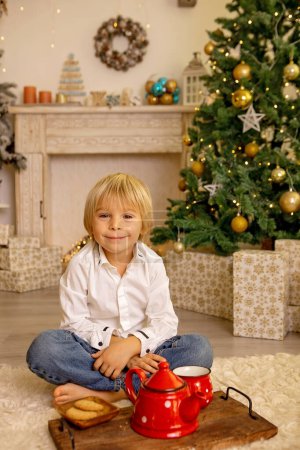Photo for Cute child, boy, playing in a decorated room for Christmas, cozy place - Royalty Free Image