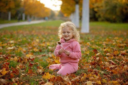 Foto de Lindos niños rubios niño y niña, caminando en el parque de otoño al atardecer, disfrutando de la hermosa naturaleza, otoño - Imagen libre de derechos
