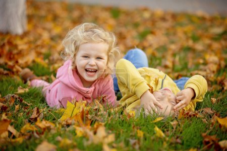 Photo for Cute blond toddler children boy and girl,walking in autumn park on sunset, enjoying the beautiful nature, autumntime - Royalty Free Image