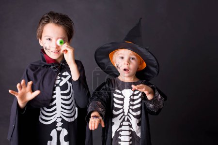 Foto de Niños. hermanos, vestidos para Halloween, jugando en casa, imagen aislada en negro - Imagen libre de derechos