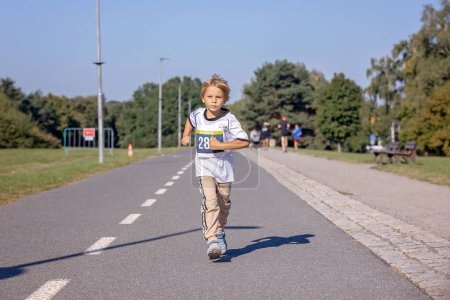 Téléchargez les photos : Jeunes enfants d'âge préscolaire, courir sur la piste dans une compétition de marathon dans le parc - en image libre de droit
