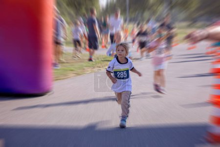 Photo for Young preschool children, running on track in a marathon competition in the park - Royalty Free Image