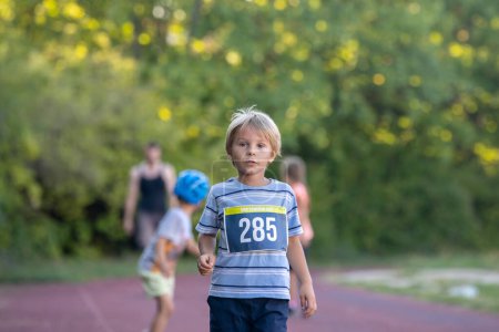 Foto de Niños preescolares, corriendo en pista en una competencia de maratón en el parque - Imagen libre de derechos