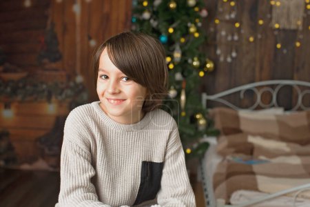 Foto de Dulce retrato de niño preadolescente, niño, sonriendo dulcemente a la cámara en Navidad - Imagen libre de derechos