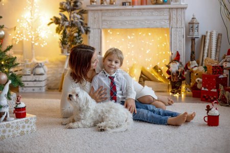 Téléchargez les photos : Maman et enfant, mignon garçon blond, assis à la maison dans un fauteuil confortable, profiter de temps en famille de qualité ensemble - en image libre de droit