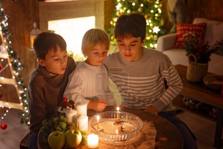 Photo for Three children, lighting candles in a nutshell, czech Christmas traditions, decorated room, family traditions - Royalty Free Image