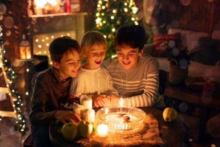 Téléchargez les photos : Trois enfants, allumer des bougies en un mot, les traditions de Noël tchèque, chambre décorée, traditions familiales - en image libre de droit