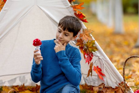 Foto de Lindos niños felices, hermanos, niños, jugando con juguetes de punto en el parque, otoño, setas, hojas, calabazas - Imagen libre de derechos