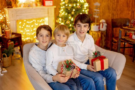Photo for Happy family, children and mom, taking family pictures in a cozy christmas studio together - Royalty Free Image