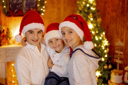 Photo for Happy family, children and mom, taking family pictures in a cozy christmas studio together - Royalty Free Image