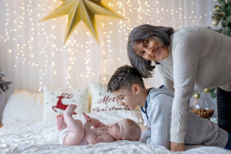Foto de Familia feliz, bebé recién nacido y hermanos mayores, mamá en casa en Navidad - Imagen libre de derechos