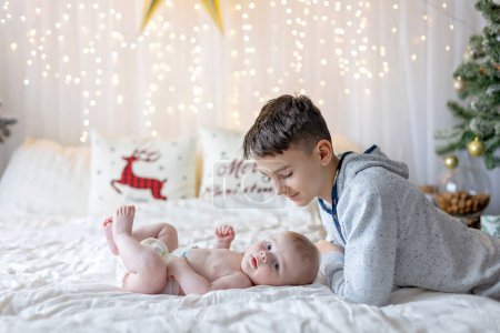 Photo for Happy family, newborn baby and older brothers, mom at home on Christmas - Royalty Free Image