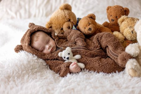 Foto de Dulce niño nuevo, niño en el oso en general, durmiendo en la cama con osos de peluche - Imagen libre de derechos