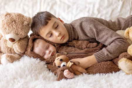 Téléchargez les photos : Doux nouveau garçon enfant, bébé garçon dans l'ours en général, dormir au lit avec des ours en peluche - en image libre de droit