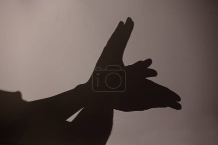 Photo for Child hands making bird on the wall, shadoows, game with shadows on the wall - Royalty Free Image