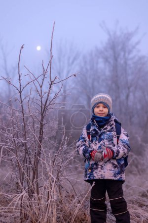 Téléchargez les photos : Enfant doux, garçon, le matin, froid glacial, aller à l'école, l'hiver - en image libre de droit