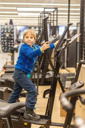 Téléchargez les photos : Enfant, garçon d'âge préscolaire, entrainement en salle de gym, centre de fitness avec installations de fitness - en image libre de droit