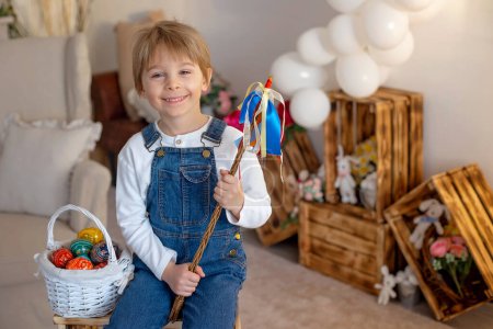 Photo for Sweet preschool boy in studio, playing with, egg for Easter and eating chocolate, child on Easter holiday at home - Royalty Free Image
