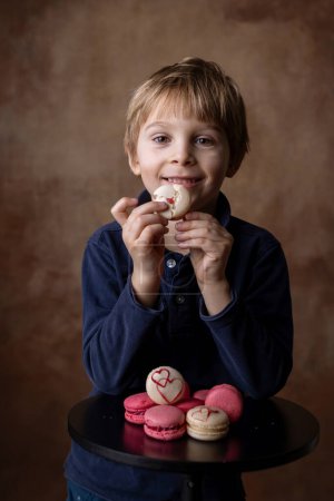 Foto de Hermoso niño rubio, niño, caja de espera con macarrones dulces para San Valentín - Imagen libre de derechos