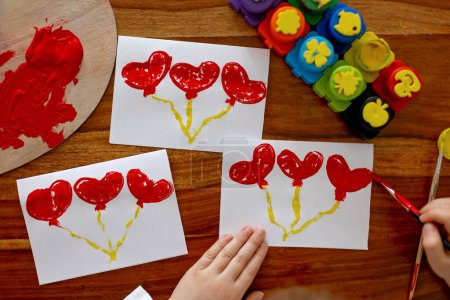 Téléchargez les photos : Enfant, faire une image d'art créatif avec des cœurs pour Valentine - en image libre de droit